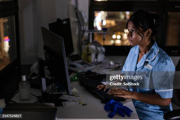 krankenschwester arbeitet bis spät in die nacht - überstunden machen stock-fotos und bilder