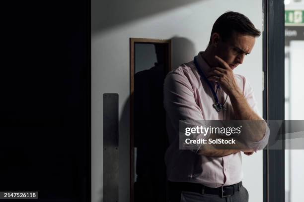 concerned doctor feeling overwhelmed - hospital doorway stock pictures, royalty-free photos & images