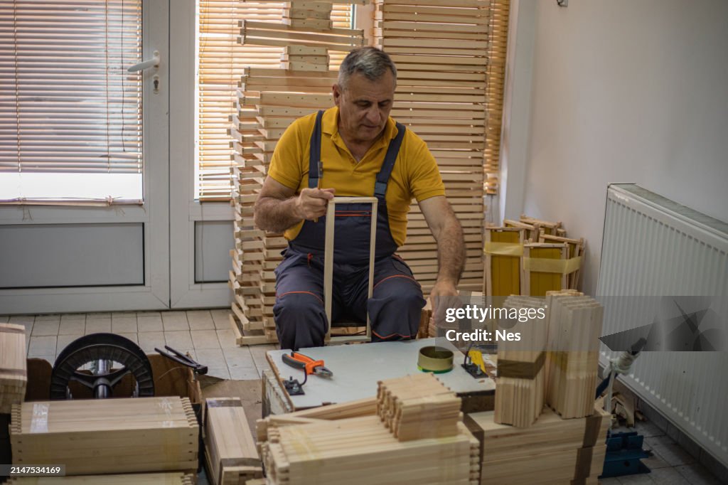 Un carpintero ensambla marcos de madera para colmenas, equipos de apicultura