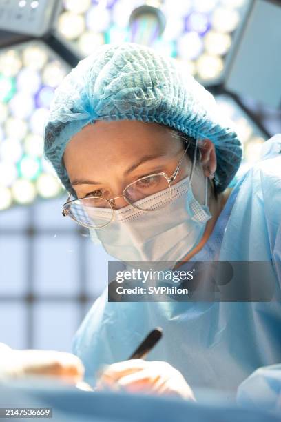 porträt des plastischen chirurgen während der operation. - autopsie stock-fotos und bilder
