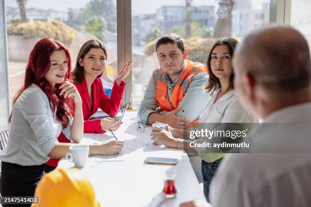 manager and creative team sitting and meeting in a modern and bright workspace boardroom - vakbond stockfoto's en -beelden