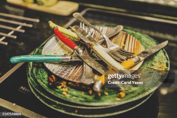 a pile of dirty dishes sit on a countertop in a kitchen - pastille pour lave vaisselle photos et images de collection