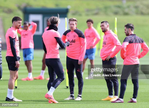 Kevin De Bruyne of Manchester City talks with Jack Grealish during a training session at Manchester City Football Academy on April 08, 2024 in...