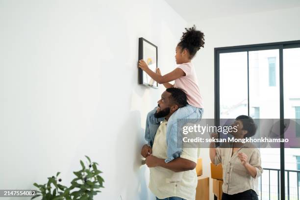 happy parents having fun while holding their small children. after moving to a new apartment - life events stock pictures, royalty-free photos & images