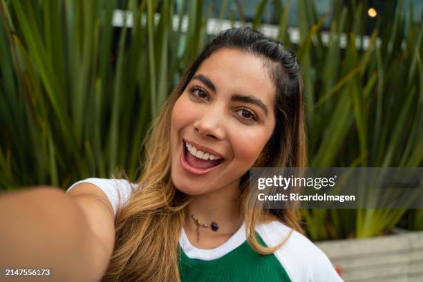 donna sorridente che guarda la fotocamera per un selfie - cultura colombiana foto e immagini stock