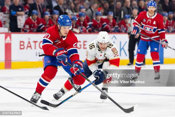 Juraj Slafkovsky of the Montreal Canadiens and Aleksander Barkov of the Florida Panthers fight for the puck during the first period of the NHL...