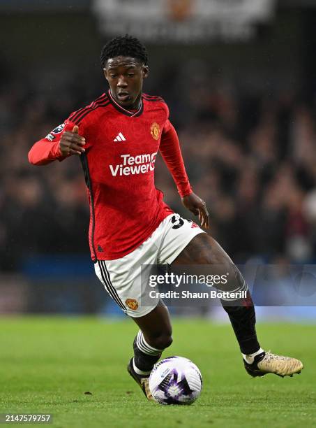 Kobbie Mainoo of Manchester United runs with the ball during the Premier League match between Chelsea FC and Manchester United at Stamford Bridge on...