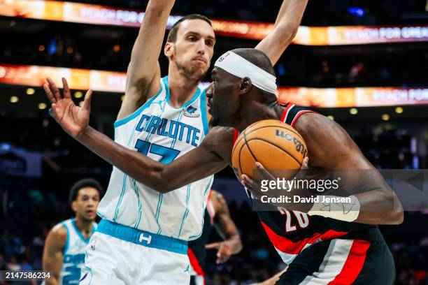 Aleksej Pokusevski of the Charlotte Hornets defends Duop Reath of the Portland Trail Blazers during the second half of a basketball game at Spectrum...