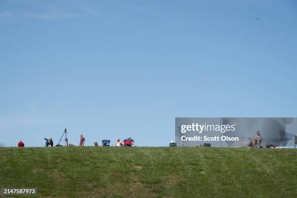 People gather on a hill on the campus of Southern Illinois University to prepare for the start of the total eclipse on April 08, 2024 in Carbondale,...