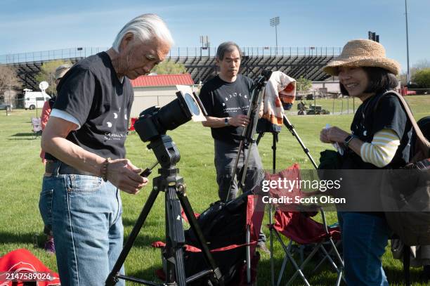 Visitors from California prepare their equipment to photograph the total eclipse from a field on the campus of Southern Illinois University on April...