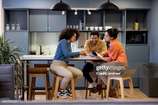business people sharing ideas in the kitchen at a coworking office - office break room stock pictures, royalty-free photos & images
