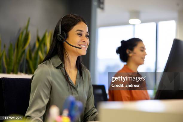 happy businesswoman using a headset while making a video call at the office - retention stock pictures, royalty-free photos & images