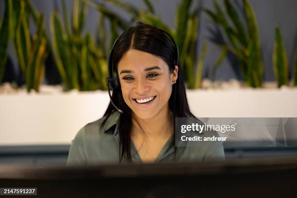 businesswoman using a headset while making a video call at the office - customer retention stock pictures, royalty-free photos & images