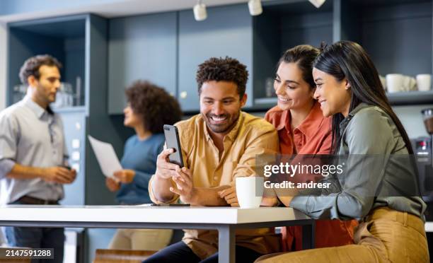 les gens d’affaires qui prennent une pause au bureau et regardent les médias sociaux à la cafétéria - faire-une-pause photos et images de collection
