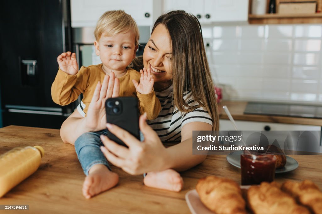 Mother and son having video call during breakfast