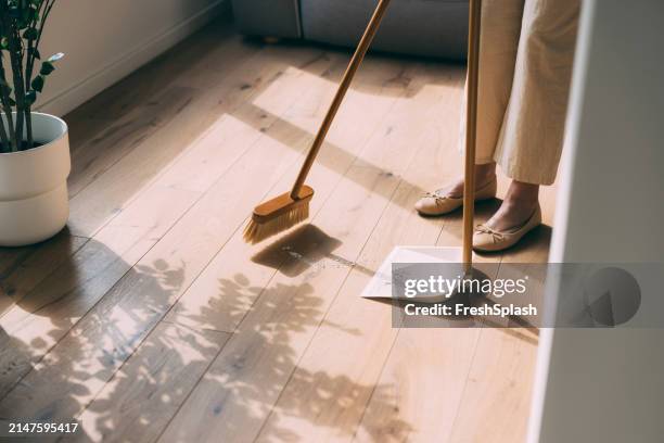 sweeping floor at home with dustpan and broom - vegen stockfoto's en -beelden