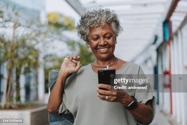 retrato de una mujer mayor que compra la bolsa de la compra - mujeres de mediana edad fotografías e imágenes de stock