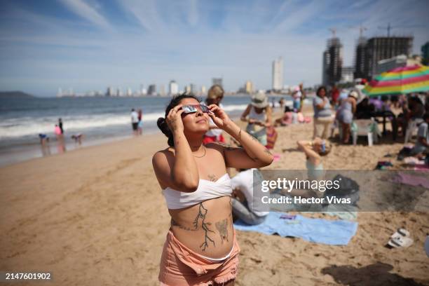 Woman watches the eclipse from the beach on April 08, 2024 in Mazatlan, Mexico. Millions of people have flocked to areas across North America that...