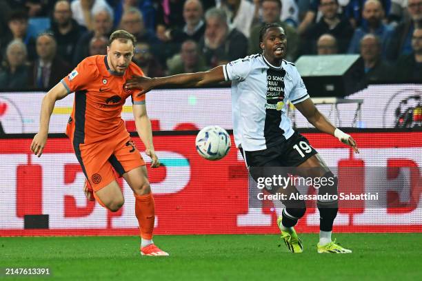 Kingsley Ehizibue of Udinese Calcio holds off Carlos Augusto of FC Internazionale as they chase the ball during the Serie A TIM match between Udinese...