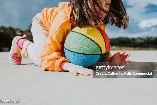 a little girl leans on a colourful basketball - hoop rolling stock pictures, royalty-free photos & images