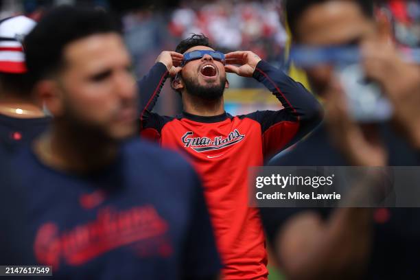 Gabriel Arias of the Cleveland Guardians looks up at the total solar eclipse before the home opener against the Chicago White Sox at Progressive...