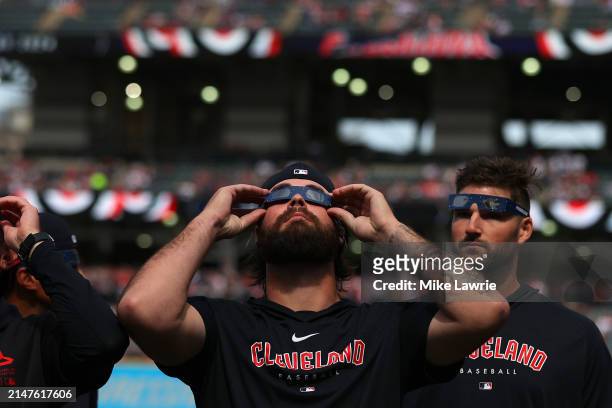 Hunter Gaddis of the Cleveland Guardians looks up at the total solar eclipse before the home opener against the Chicago White Sox at Progressive...