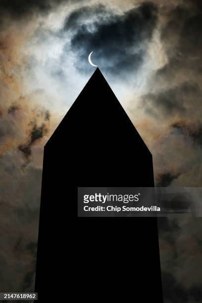The solar eclipse is seen above the Washington Monument on April 08, 2024 in Washington, DC. People have traveled to areas across North America that...