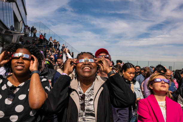 People watch a partial solar eclipse on the observation deck of Edge at Hudson Yards on April 08, 2024 in New York City. While New York City isn't in...