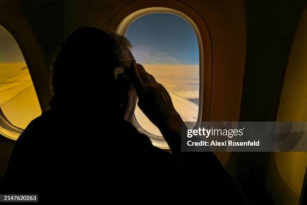 People on a flight view a partial eclipse on the left side of the aircraft flying from New Jersey to Los Angeles on April 08, 2024 in flight....