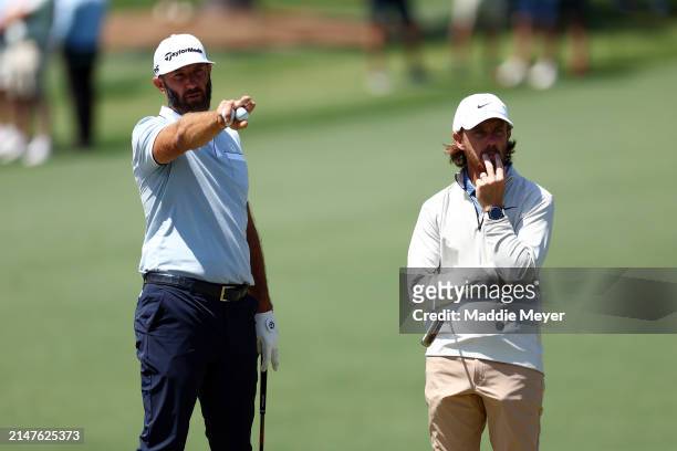 Dustin Johnson of the United States and Tommy Fleetwood of England look on during a practice round prior to the 2024 Masters Tournament at Augusta...