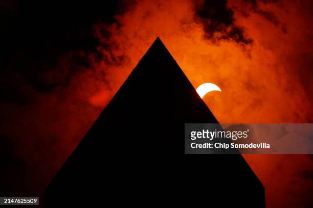 The solar eclipse is seen above the Washington Monument on April 08, 2024 in Washington, DC. People have traveled to areas across North America that...