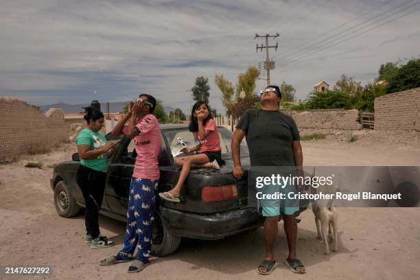 Family watches the eclipse using special glasses on April 8, 2024 in 22 de Febrero, Mexico. Millions of people have flocked to areas across North...