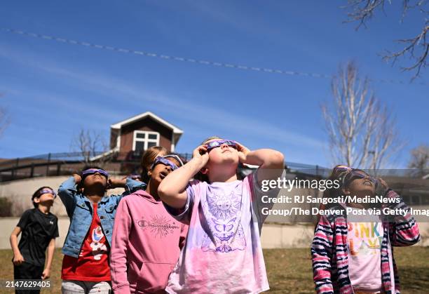 Fourth graders from STEM School Highlands Ranch watch the solar eclipse at Littles Creek Park during a field trip in Littleton, Colorado on April 8,...