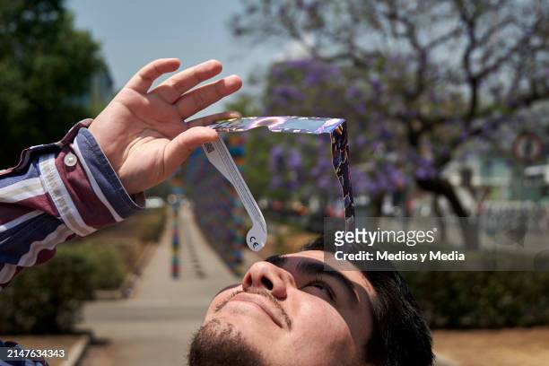 Person watches the solar eclipse on April 8, 2024 in Mexico City, Mexico. Millions of people have flocked to areas across North America that are in...