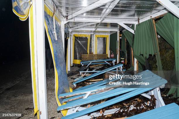 Debris of benches and tables inside the cafe at Castle Beach where three beach huts were swept into the sea on the evening high tide on April 08,...