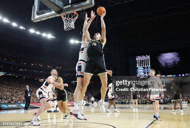 Zach Edey of the Purdue Boilermakers attempts a shot while being guarded by Donovan Clingan of the Connecticut Huskies in the first half during the...