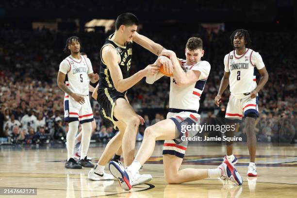 Zach Edey of the Purdue Boilermakers and Donovan Clingan of the Connecticut Huskies battle for a loose ball in the first half during the NCAA Men's...