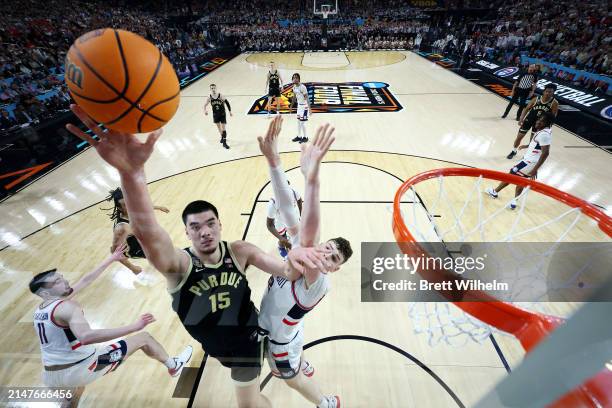 Zach Edey of the Purdue Boilermakers shoots the ball, defended by Donovan Clingan of the Connecticut Huskies during the second half in the NCAA Men's...