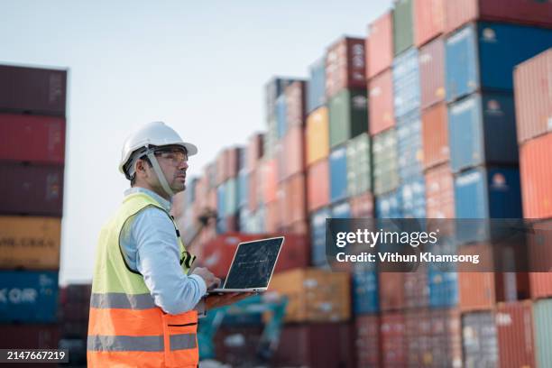 male engineer working at containers yard. cargo port storage for transportation and trading. - fracht stock-fotos und bilder