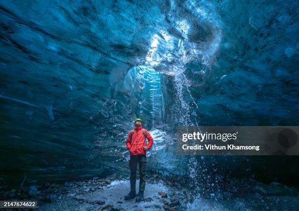 ice cave and traveler at iceland - vatnajokull photos et images de collection