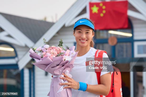 Zheng Qinwen of China poses for a photo with a bouquet during a training session ahead of the Billie Jean King Cup 2024 Asia-Oceania Group I campaign...