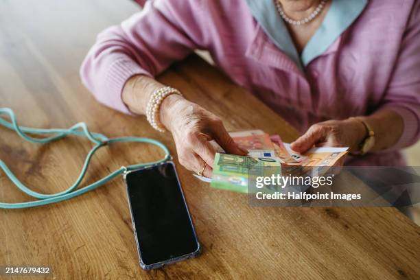 telephone scams targeting seniors. scammer making phone call with elderly woman, asking for money, demanding personal, sensitive informations over phone without verification. - scammer trickbetrüger stock-fotos und bilder