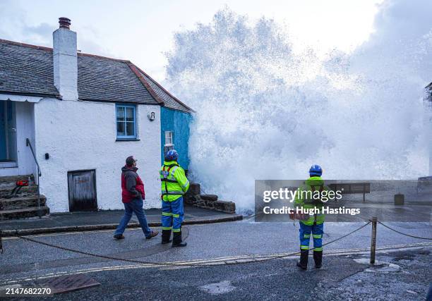 Coastguard personnel look on as waves crash over the harbour wall onto the street on April 09, 2024 in St Ives, Cornwall, England. On Monday, the Met...