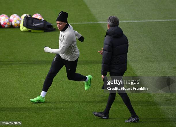 Kylian Mbappé of PSG runs past Luis Enrique, head coach of PSG during a training session at PSG Campus on April 09, 2024 in Paris, France.