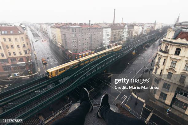 sitting on rooftop admiring elevated train traveling through berlin - vertigine foto e immagini stock