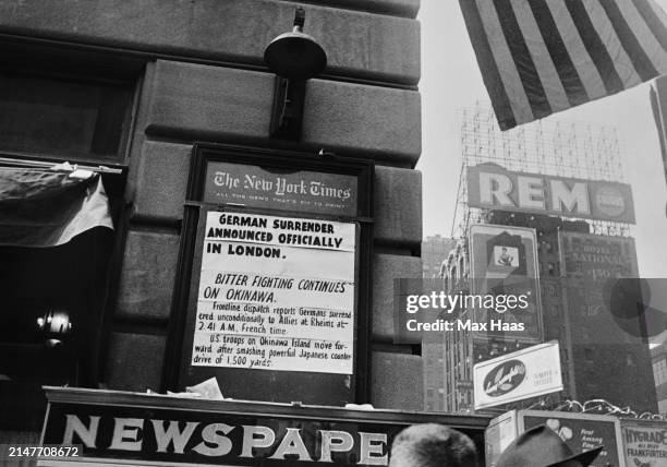 New York Times newsboard announcing Germany's surrender of its armed forces marking the end of WWII in Europe, New York City, US, 8th May 1945.