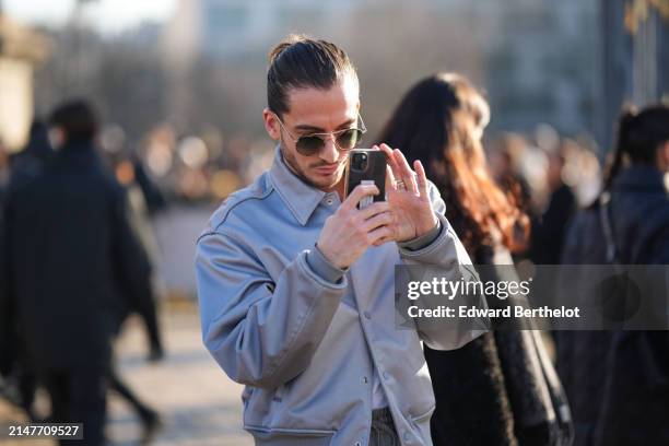 Guest wears a gray bomber jacket, sunglasses, outside Dior, during the Menswear Fall/Winter 2024/2025 as part of Paris Fashion Week on January 19,...