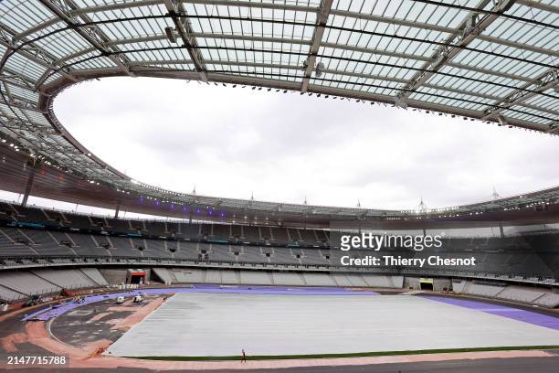 Workers build the athletics track at the Stade de France which will host the athletics events of the Olympic Games on April 09, 2024 in Saint Denis,...