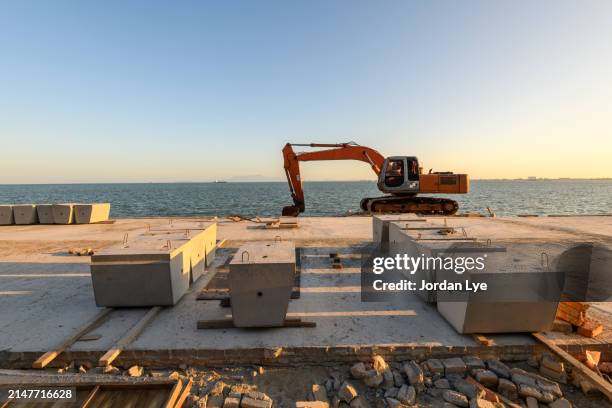 hydraulic excavator earth mover installing concrete block - grävmaskin bildbanksfoton och bilder