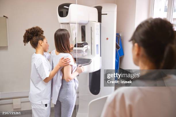 femme médecin et patiente pendant le test de mammographie dans la salle d’examen - blouse dexamen médical photos et images de collection